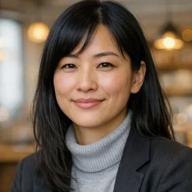 Woman in her early thirties, straight black hair, calm expression, gray turtleneck